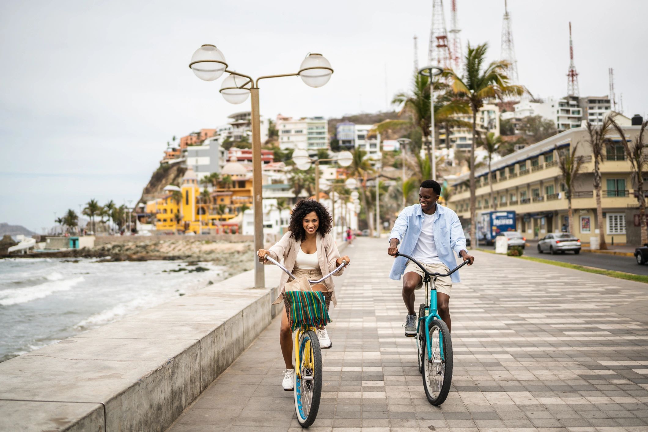 Couple riding e-bikes along a coastal road